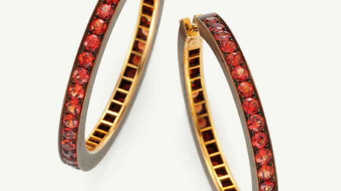Elegant gold hoop earrings adorned with red gemstones.